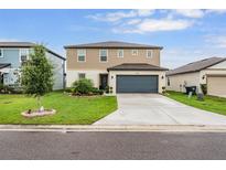 Inviting two-story home featuring manicured lawn, tidy landscaping, and a two-car garage at 5660 Keaton Springs Dr, Lakeland, FL 33811