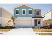 Charming two-story home featuring a two-car garage and colorful exterior paint at 742 Ambleside Dr, Haines City, FL 33844