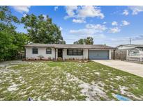 Charming single-story home with a well-maintained lawn and attached two car garage and freshly painted white brick at 229 Temple Ave, Fern Park, FL 32730