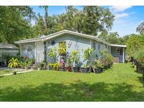 Charming single-story home with well-manicured lawn and adorned with numerous potted plants and decorations at 306 Avenue A E, Winter Haven, FL 33880