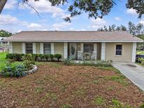 Charming single-story home with a well-maintained lawn and cozy front porch with rocking chairs at 4003 Prairie Bend Ln, Lakeland, FL 33812