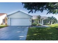 Charming single-story home featuring a well-manicured lawn and an attached two-car garage at 647 San Pedro Dr, Lady Lake, FL 32159