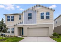 Charming two-story home featuring a light beige exterior with a two car garage at 1221 Tidal St, Haines City, FL 33844