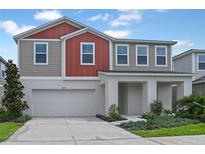 Two-story home featuring a two car garage, landscaped yard and a modern stucco and siding design at 1233 Tidal St, Haines City, FL 33844