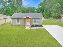 Charming single-story home featuring a cozy front porch, fresh landscaping, and a well-manicured lawn at 5969 Nw 65Th St, Ocala,, FL 34482