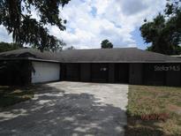 Traditional single-story home with an attached two-car garage and large driveway at 5190 Starling Dr, Mulberry, FL 33860