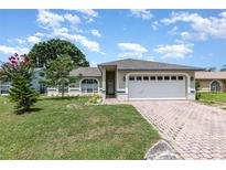 Charming one-story home with a brick driveway, well-maintained lawn, and inviting curb appeal at 216 Kingshill Se Ct, Winter Haven, FL 33884