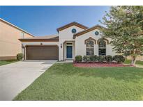 Charming single-Gathering home with a well-manicured lawn, two-car garage, and blue front door at 3067 Princewood Dr, Minneola, FL 34715