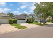 Charming single Gathering home featuring three car garage and well-manicured lawn at 12844 Oulton Cir, Orlando, FL 32832