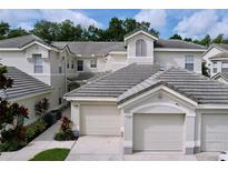 Charming townhouse featuring a tile roof, two-car garage, and well-maintained landscaping at 776 Grasslands Village Cir # 776, Lakeland, FL 33803