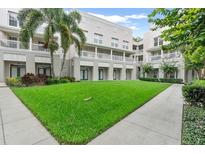 Condominium building with a lush green lawn and mature trees at 539 Water St # 539, Kissimmee, FL 34747