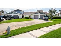 Well-maintained townhome featuring attached garages, manicured lawn and long driveway at 62 Lakepointe Cir, Kissimmee, FL 34743