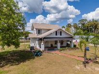 Charming two-story home with a brick walkway, landscaped yard, and a covered front porch at 4145 Willis Rd, Mulberry, FL 33860