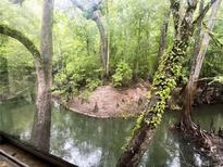 Scenic waterfront view with lush trees, creating a serene and natural backdrop to the property at 12828 Sw 49Th Ter, Webster, FL 33597
