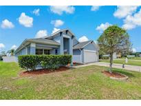 Charming single-story home with light blue exterior, two car garage and manicured lawn at 2576 Boots Rd, Lakeland, FL 33810