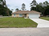 Charming single-story home boasts a well-manicured lawn and attached two-car garage at 5635 Nw 61St Ct, Ocala, FL 34482