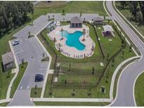 Aerial view of community pool with ample parking, picnic area, and playground for residents at 3628 Diving Dove Ln, Bartow, FL 33830