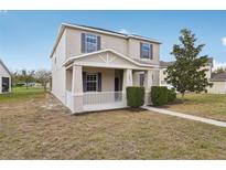 Charming two-story home with front porch, manicured landscaping, and neutral color scheme at 1893 Rafton Rd, Apopka, FL 32703