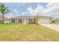 Charming brick home featuring an attached garage, well-maintained lawn, and a cozy, inviting appeal at 1856 Laredo Dr, Deltona, FL 32738