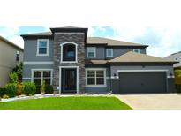 Beautiful two-story home with a stone-accented entrance and well-manicured lawn at 1319 Heavenly Cv, Winter Park, FL 32792