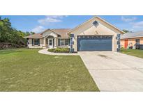Charming single-story home with a well-manicured lawn and attached two-car garage at 2645 Sw 148Th Ln, Ocala, FL 34473