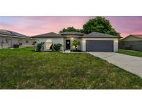 Charming single-story home with stucco exterior, arched windows, and a well-maintained lawn at 1003 Edmund Ave, Dundee, FL 33838