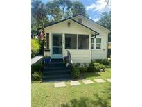 Charming home featuring a cozy porch, blue door, and well-maintained landscaping at 734 Maryland Ave, Winter Park, FL 32789