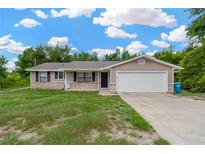 Charming single-story home with a two-car garage, brick accents and an inviting entrance at 562 Nardello Dr, Deltona, FL 32725