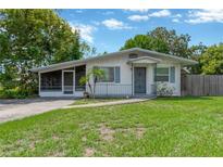 Charming single-story home with a screened porch, well-maintained lawn, and inviting curb appeal at 6906 Cocos Dr, Orlando, FL 32807