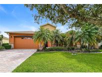 Charming home featuring a well-manicured lawn, mature landscaping, and a welcoming front entrance at 154 Indian Wells Ave, Kissimmee, FL 34759