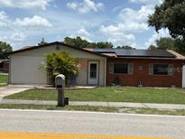 Charming single-story home with a well-maintained lawn and solar panels on the roof at 3439 Swindell Rd, Lakeland, FL 33810