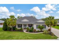 Charming single-story home featuring lush landscaping and a welcoming front porch with rocking chairs at 2973 Blackwater Creek Dr, Lakeland, FL 33810