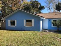 Charming home featuring light blue paint and white trim, set against lush greenery and a sunny sky at 1257 Dal Maso Dr, Daytona Beach, FL 32117