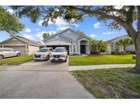 Charming single-story home with well-manicured lawn and driveway parked with vehicles at 4931 Jetton Dr, Orlando, FL 32837