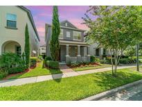 Charming two-story home with well-manicured lawn and inviting front porch with decorative columns at 9349 Mira Valle Ln, Winter Garden, FL 34787