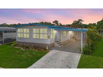 Charming single-story home with well-maintained lawn, blue accents, and a covered carport providing convenience and curb appeal at 932 Cassandra Ln, Lakeland, FL 33809