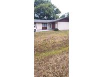 Modest single story home with a mix of siding and a well manicured green lawn in the front of the property at 2505 W Parker St, Lakeland, FL 33815
