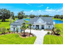 Stunning home with a white exterior, meticulous landscaping, complemented by a serene lake view at 12902 Sw 138Th Loop, Dunnellon, FL 34432