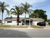Charming single-story home with well-maintained landscaping and inviting front porch with sitting area at 17569 Se 107Th Ct, Summerfield, FL 34491