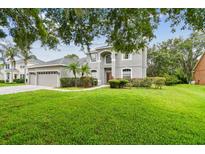Charming two-story home with a well-manicured lawn, mature trees, and an attached three-car garage at 297 Beacon Pointe Dr, Ocoee, FL 34761