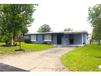 Charming single-story home with a well-manicured lawn and a driveway leading to a covered carport at 5 Moonlight Ln, Winter Haven, FL 33884