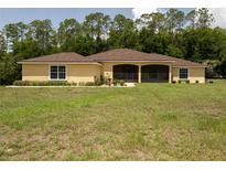 Lovely one story home with a well-maintained lawn, lush greenery, and a screened-in porch at 21590 Sw 84Th Loop, Dunnellon, FL 34431