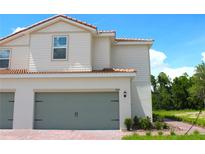 Charming two-story home featuring a two-car garage, beautiful landscaping and a welcoming red brick walkway at 584 Bay Leaf Dr, Poinciana, FL 34759