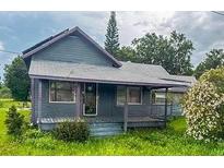 Charming single-story home featuring a covered front porch and mature landscaping at 225 N Palmetto Ave, Fort Meade, FL 33841