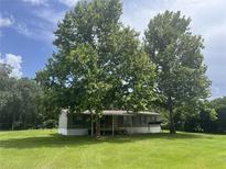 Quaint single-story home with neutral siding and mature trees in a sprawling lawn at 2777 Cr 673, Bushnell, FL 33513