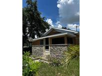 Charming home featuring a stone facade, well-manicured greenery, and a cozy, inviting entrance at 701 N 7Th St, Haines City, FL 33844