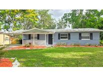Charming single-story home featuring a well-manicured lawn, tasteful landscaping, and a cozy covered front porch at 5834 Forest Grove Blvd, Orlando, FL 32808