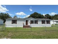 Charming single-story home with light siding, brown shutters, and well-maintained front yard at 4861 Myrtle View N Dr, Mulberry, FL 33860