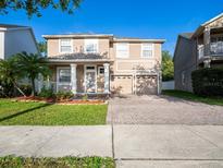 Charming two-story home featuring a well-manicured lawn and a two-car garage at 10084 Moss Rose Way, Orlando, FL 32832