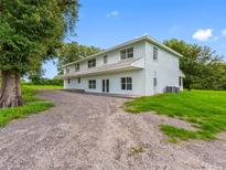 Spacious two-story home with ample parking and verdant landscaping, offering a serene and private setting at 2440 S Wallace Rd, Bartow, FL 33830